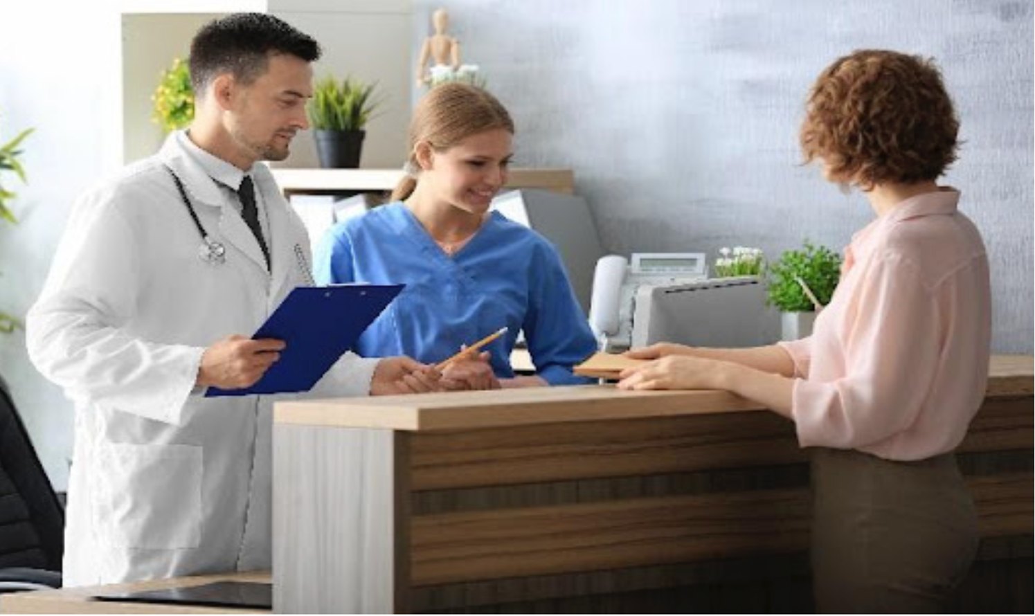 Physician and front-desk staff assisting a patient at the clinic reception desk